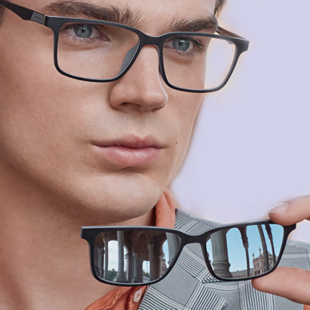 Mann mit schwarzer Brille hält den passenden magnetischen Sonnenclip in der Hand