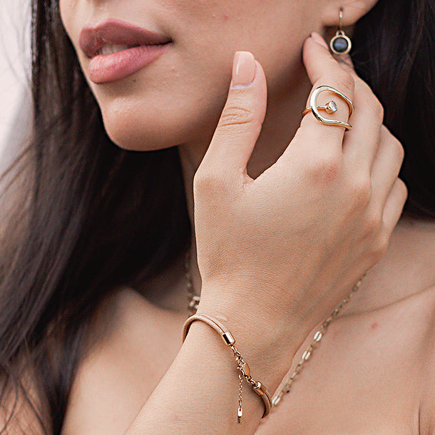 Frau trägt goldenen Ring, Armband und Ohrring – Second-Hand-Schmuck bei Weißmann